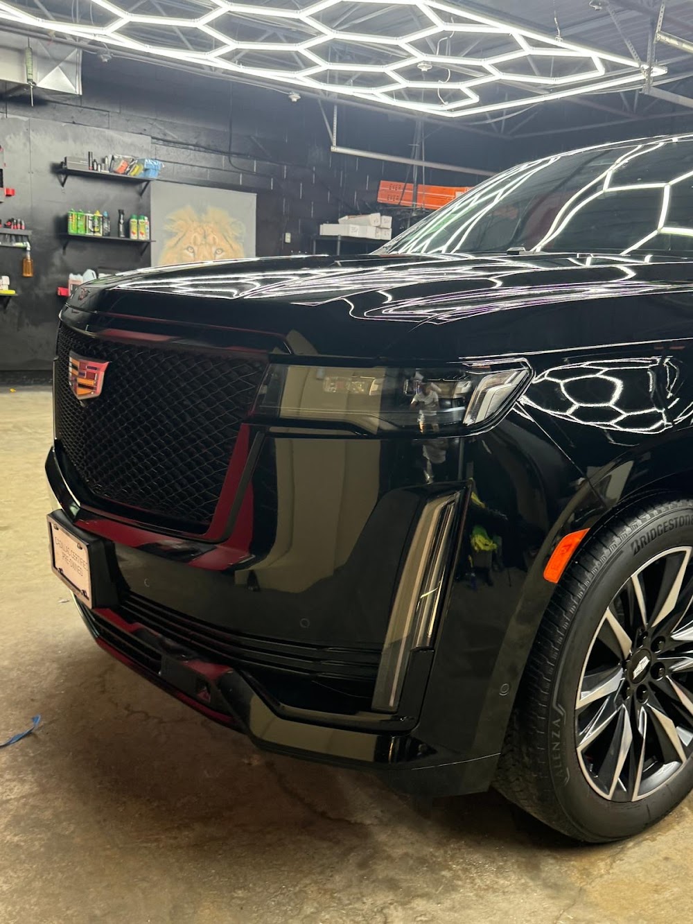 Black Cadillac Escalade receiving automotive window tint and interior UV protection inside the WPEG Customs Winnipeg install bay