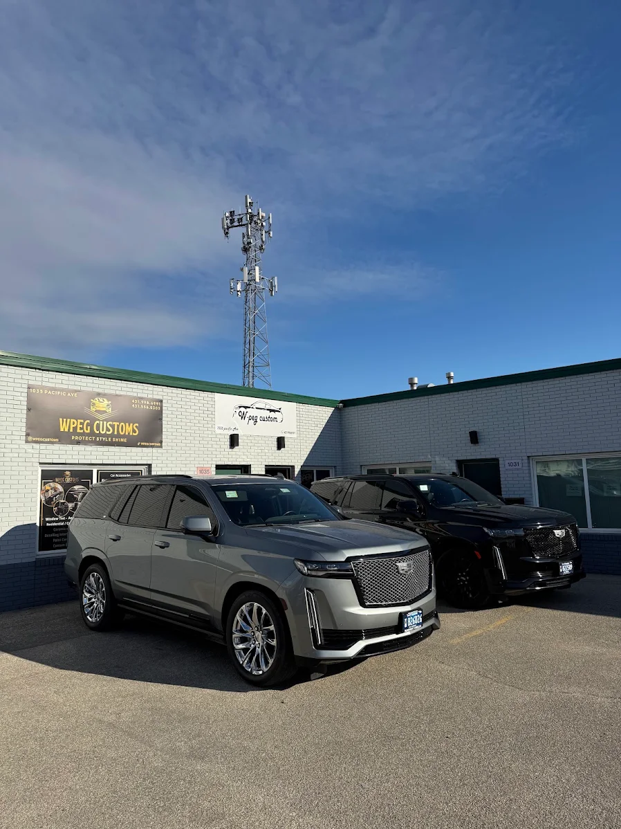 WPEG Customs Winnipeg shop storefront at 1035 Pacific Ave with Cadillac Escalades